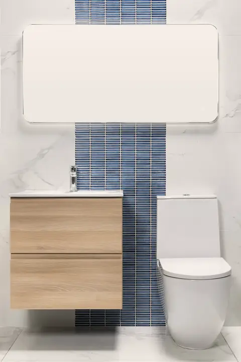 Salle de bain en grands carreaux clairs, bande de faïence bleue verticale derrière le meuble vasque